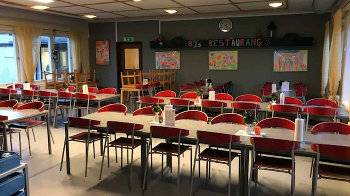Matsal i anslutning till Ätranskolan med bord, stolar och kök.