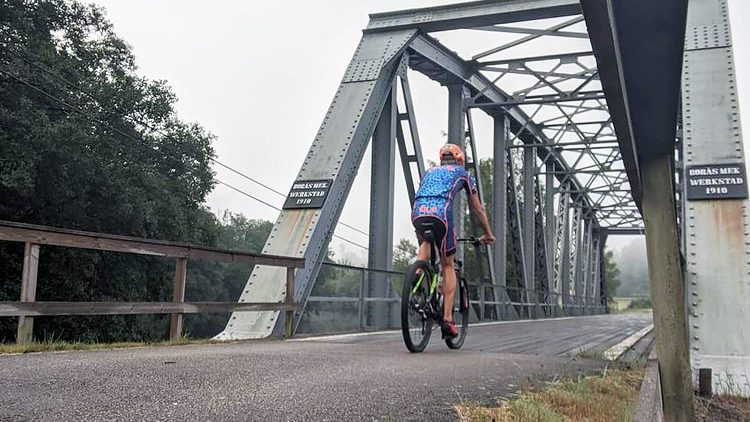 En man cyklar över gamla järnvägsbron i Ätran.